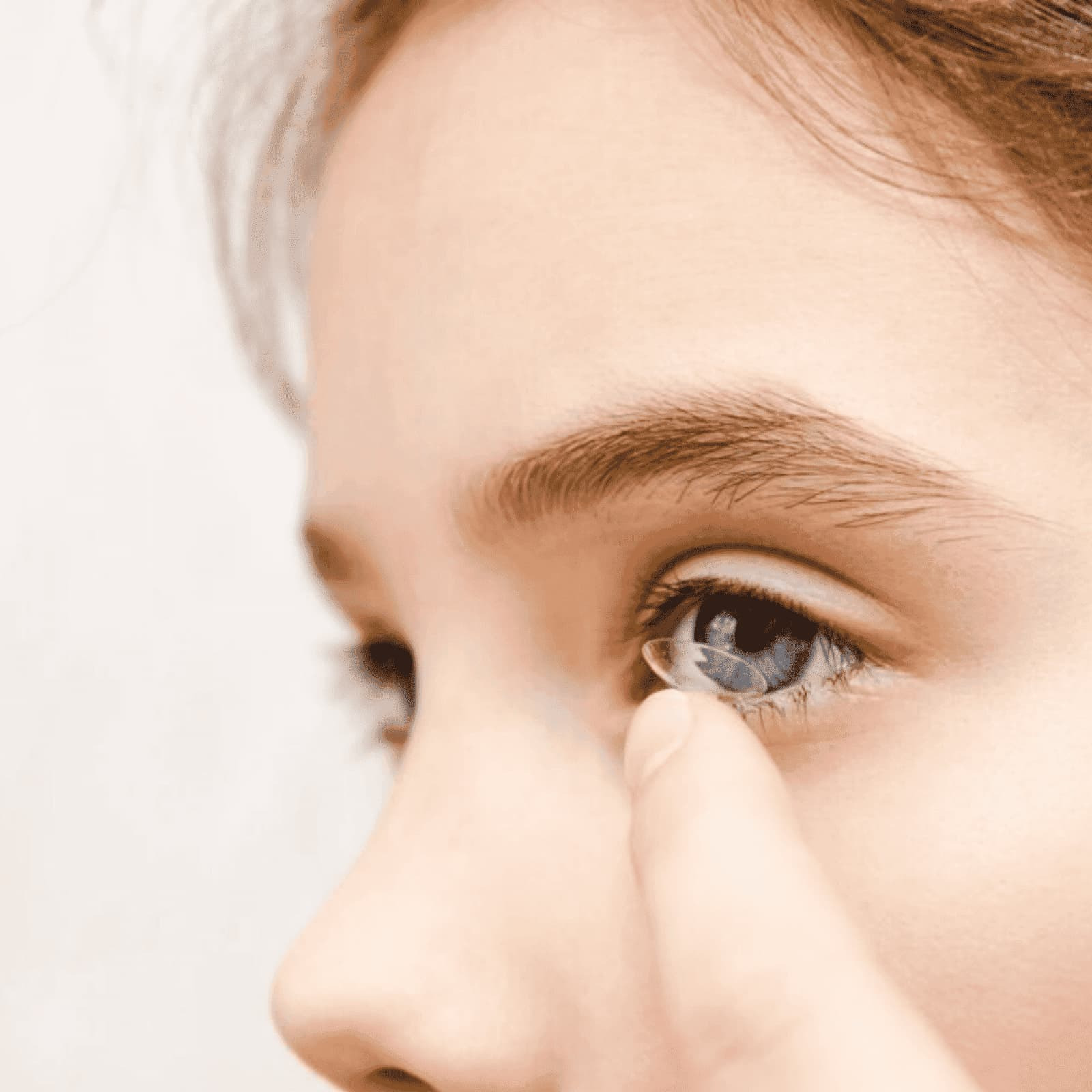 A child fitting her contact lenses