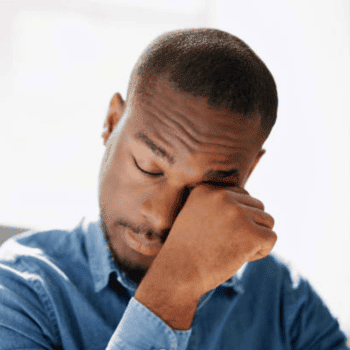 A man rubbing his eyes in discomfort