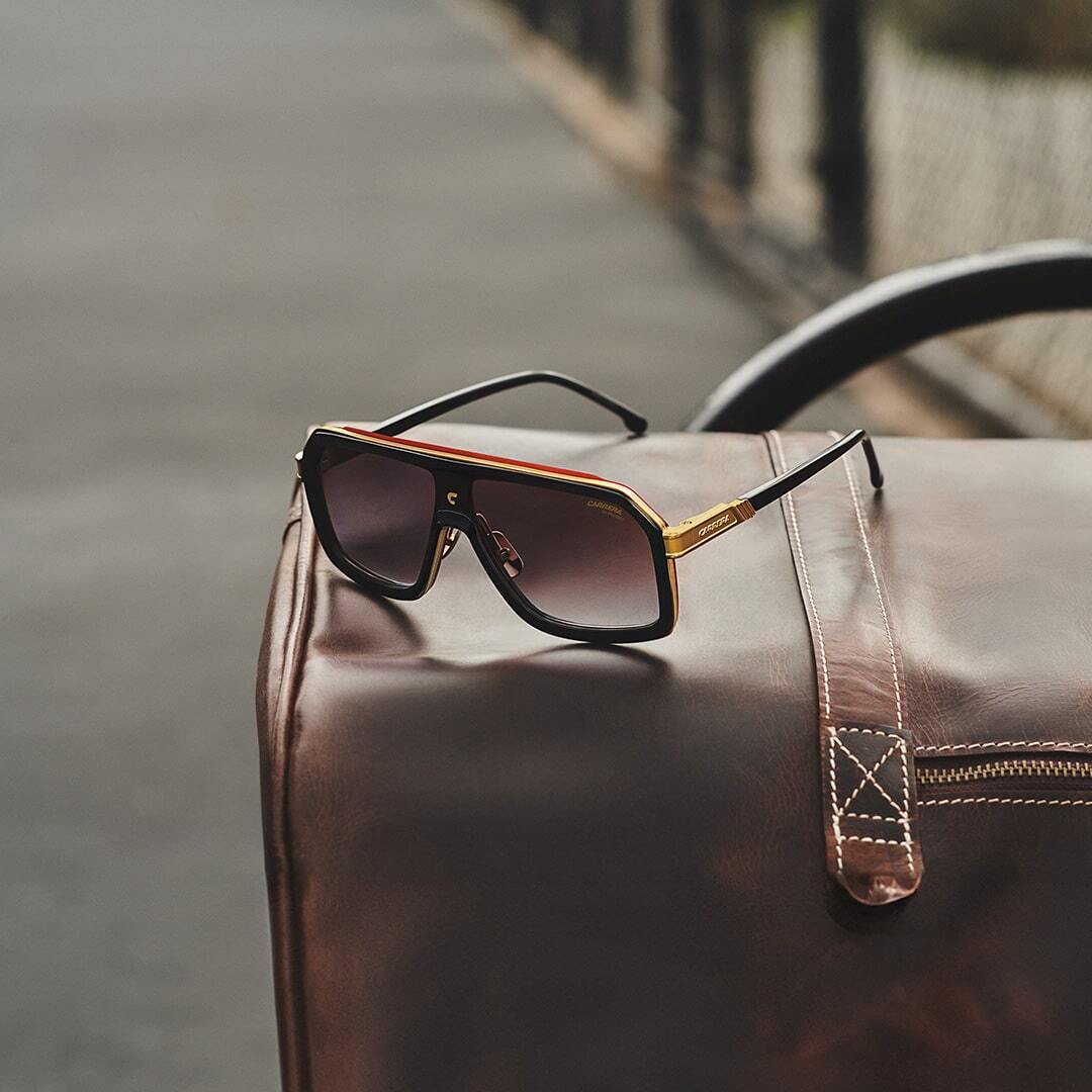 Side view of Carrera sunglasses with black frame and red detailing.