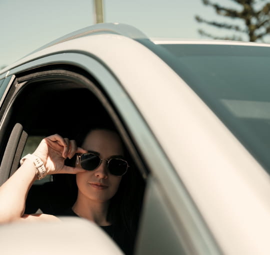 Woman wearing SEIKO Curved Polarised Sun lenses while driving, available at Dynamic Vision Optometrists in South Africa